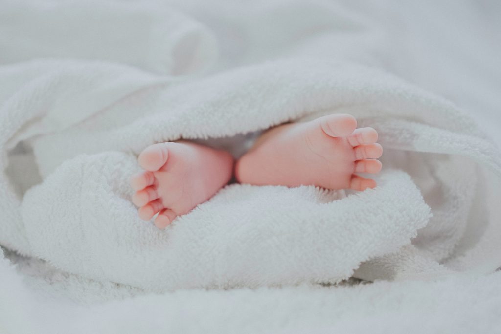 Pieds de nouveau-né entourés d'une serviette de bain blanche